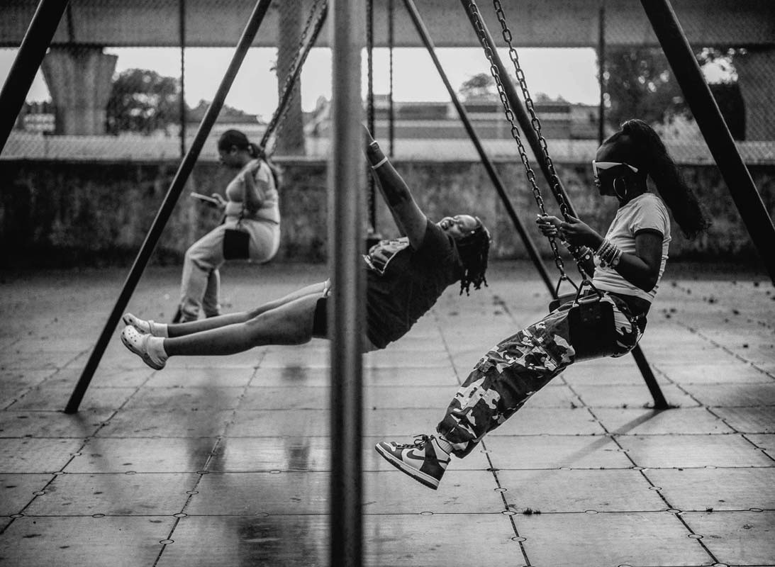Kobiety na huśtawkach na placu zabaw, czarno-biała fotografia